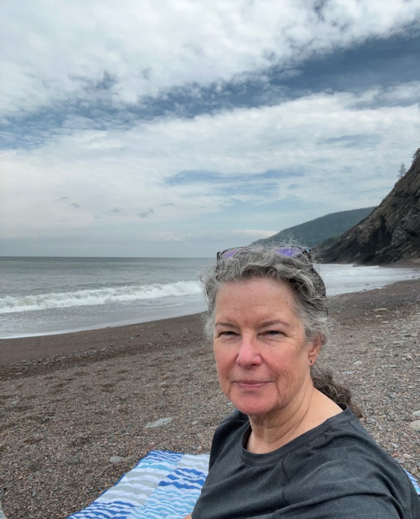 Journal writing on the pebbly beach.